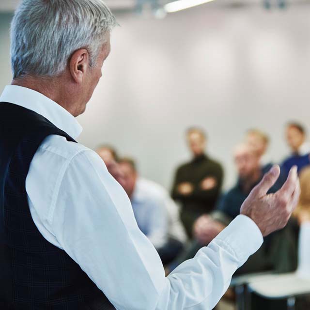 Geschaeftsmann spricht vor Zuhoerern