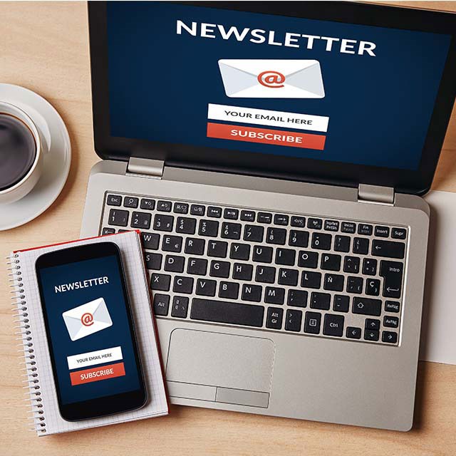 Laptop mit Mobiltelefon und Hinweis Newsletter